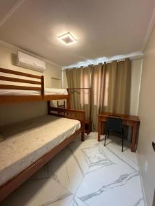 a room with two bunk beds and a desk at Apartamento confortável in Boa Vista