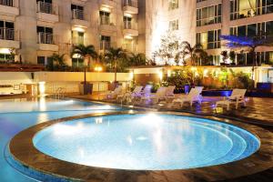 a large swimming pool in the middle of a building at Fancy and Nice Studio at El Royale Apartment By Travelio in Bandung