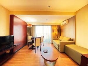 a living room with a couch and a table at Fancy and Nice Studio at El Royale Apartment By Travelio in Bandung