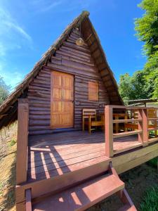 a log cabin with a deck and a door at Phu Aunna in Ko Phayam