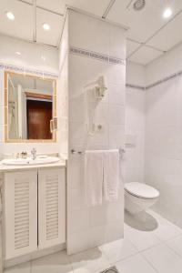 Un baño blanco con inodoro y lavabo. en Precise Resort Tenerife, en Puerto de la Cruz