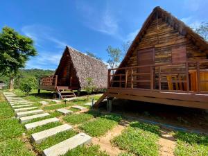 a log cabin with a porch and a house at Phu Aunna in Ko Phayam
