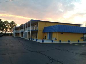 Belmont Inn and Suites في هامبتون: مبنى اصفر كبير بسقف ازرق