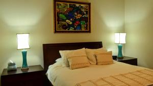 een slaapkamer met een bed met twee lampen erop bij Villa Athena in Rio Grande +12 foto's