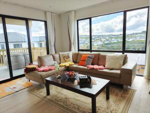 Uma área de estar em Orewa New house with view on deck near Cafe,bush & river
