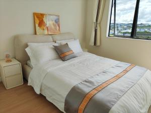 Uma cama ou camas num quarto em Orewa New house with view on deck near Cafe,bush & river