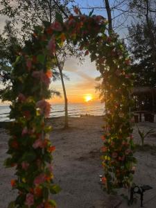 - une arche de fleurs sur la plage au coucher du soleil dans l'établissement Mai Rut Beach Eco Resort and Camping, à Ban Nong Wiwat