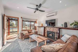 ein Wohnzimmer mit Couch und Kamin in der Unterkunft Porepunkah Cottage in Porepunkah