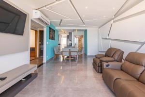 a living room with a couch and a table at Apartamento pe na areia nas pitangueiras in Guarujá