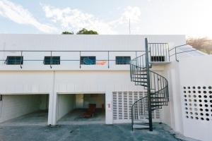 een wenteltrap aan de zijkant van een wit gebouw bij Spice Motel Okinawa in Kitanakagusuku