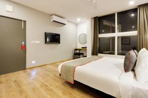 a hotel room with a bed and a window at Super townhouse moosapet Rcc Prime in Hyderabad