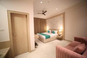 una camera d'albergo con un letto e un divano di raghukul sadan a Faizābād