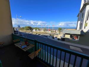 un balcone con tavolo e vista sull'oceano di Le Maxaudant Duplex avec Balcon et Vue sur Mer a Luc-sur-Mer