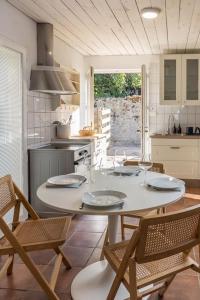 a kitchen with a white table and chairs and a kitchen with at Maison au coeur du Croisic idéalement placée ! in Le Croisic