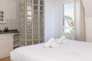 a white bedroom with a white bed and a window at Maison 5 chambres au cœur du Croisic in Le Croisic