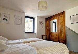 a bedroom with a bed and a wooden door at Maison Vidal, au pied de l'Aubrac in Coubisou