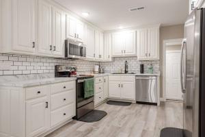 a kitchen with white cabinets and stainless steel appliances at Bourbon Trail Bungalow in Lebanon