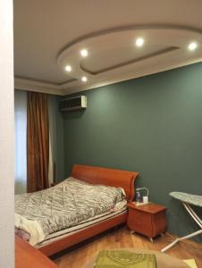 a bedroom with a bed and a green wall at Comfortable Room in Baku
