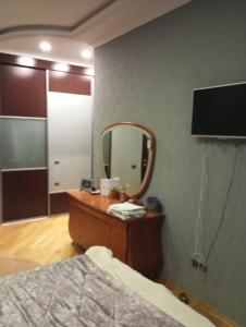 a bedroom with a bed and a mirror and a dresser at Comfortable Room in Baku