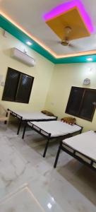 two beds sitting in a room with a ceiling at Mallikarjun Residency with AC in Akalkot