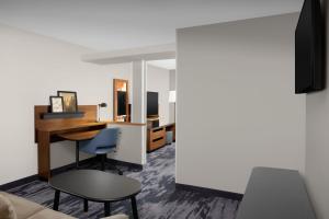 a living room with a desk and a chair at Fairfield Inn & Suites Dulles Airport in Sterling