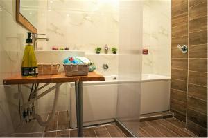 a bathroom with a tub and a table with a bottle of wine at Ayasofia Suite jakuzzi 2 BedRooms balcony in Thessaloniki
