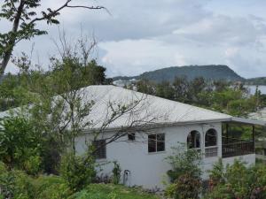 a white house with a roof and trees at Room With A View & Apartment Style in Port Vila