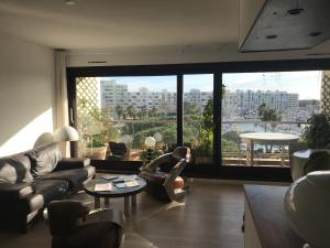 - un salon avec des canapés et des chaises ainsi qu'une grande fenêtre dans l'établissement T3 vue port 200m de la plage 2 chambres avec garage, à Carnon-Plage