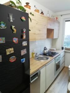 a kitchen with a black refrigerator and a sink at Apartament Szept Plaży in Kołobrzeg