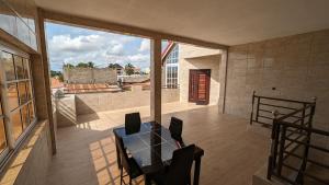 a patio with a table and chairs on a balcony at Clarisse lodge in Lomé