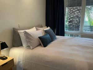 una camera da letto con un letto con cuscini e una finestra di St Kilda apt close to beach a Melbourne