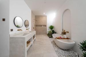 ウルワツにあるUlu Villaのバスルーム(大型バスタブ、シンク、バスタブ付)