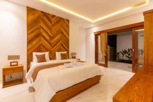 a bedroom with a large bed with a wooden headboard at Sapta D'Villa Residence by Purely in Ubud +40 photos