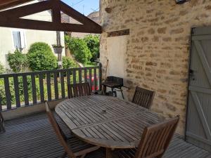 drewniany stół i krzesła na balkonie w obiekcie La Terrasse - Old Winemaker's Cottage in St Gengoux w mieście Saint-Gengoux-le-National +25 zdjęć