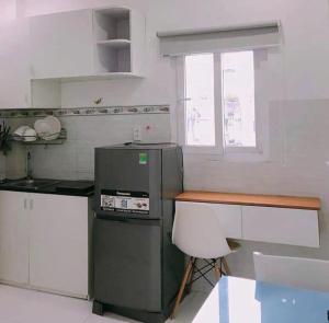 une cuisine avec un réfrigérateur et une table à l'intérieur dans l'établissement Happy Apartment, à Hô-Chi-Minh-Ville