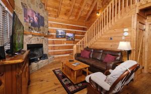 a living room with a couch and a television in a cabin at Highland Hideaway in Gatlinburg