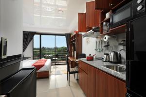 a kitchen with a sink and a bed in a room at Studio 777 Condo MaiKhao in Ban Mai Salae