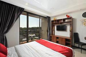 a bedroom with a bed and a television and a balcony at Studio 777 Condo MaiKhao in Ban Mai Salae