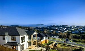 uma fila de casas num subúrbio com uma auto-estrada em Orewa New house with view on deck near Cafe,bush & river em Orewa