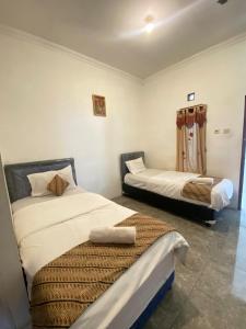 una camera con due letti di Sastro Inn Syariah Hotel Malioboro a Yogyakarta
