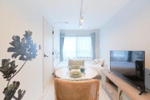 a living room with a table and a couch at RIZOTIA Hakusan by Tranova in Tokyo