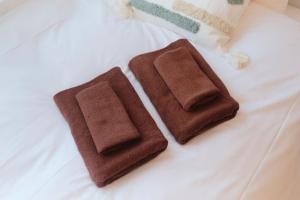 two brown towels sitting on top of a bed at RIZOTIA Hakusan by Tranova in Tokyo