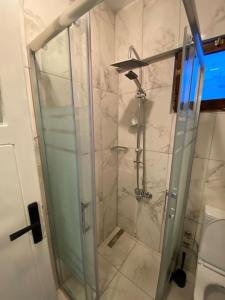 une douche avec une porte vitrée dans une salle de bain dans l'établissement Çanakkale Kordonda Boğaz Manzaralı Daire, à Çanakkale 10 autres photos