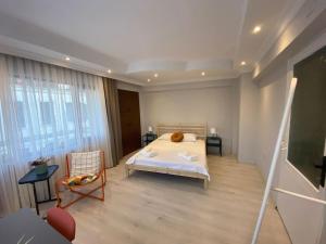 une chambre avec un lit et une chaise dans une pièce dans l'établissement Çanakkale Kordonda Boğaz Manzaralı Daire, à Çanakkale