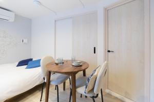 a bedroom with a bed and a wooden table and chairs at RIZOTIA Hakusan by Tranova in Tokyo +44 photos