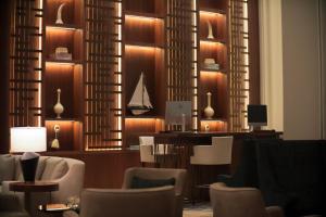 a lobby with chairs and a desk with a sailboat on the wall at Hilton Al Khobar King Fahd Causeway in Al Khobar