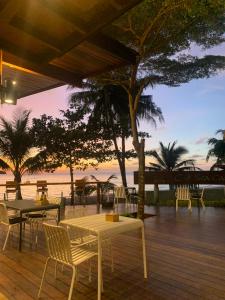eine Terrasse mit Tischen und Stühlen und Meerblick in der Unterkunft Kai Bae Beach Resort Koh Chang in Ko Chang + 37 Fotos