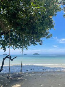 zwei Schaukeln von Bäumen am Strand in der Unterkunft Kai Bae Beach Resort Koh Chang in Ko Chang