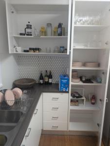Una cocina con gabinetes blancos y un fregadero. en Ground Floor Elwood village Apartment, en Melbourne
