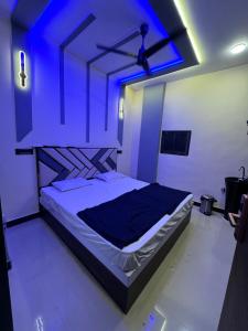 ムンバイにあるBudget home stay in kalina near bkcのベッドルーム1室(青い照明付きのベッド1台付)